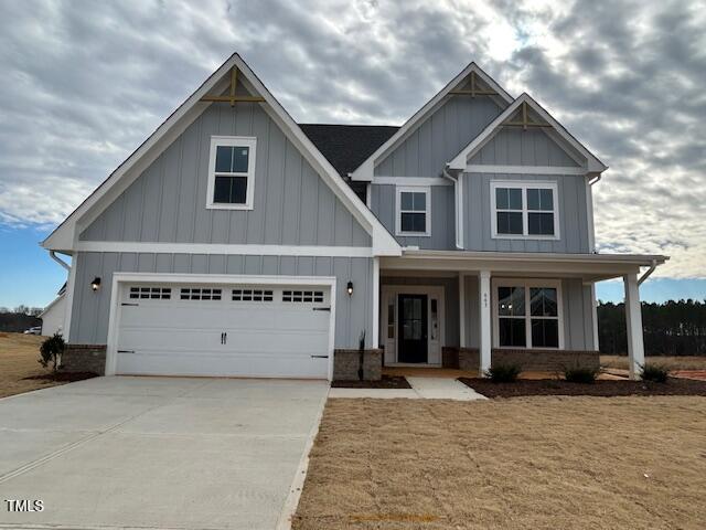 craftsman-style house with a garage, a front lawn, and a porch