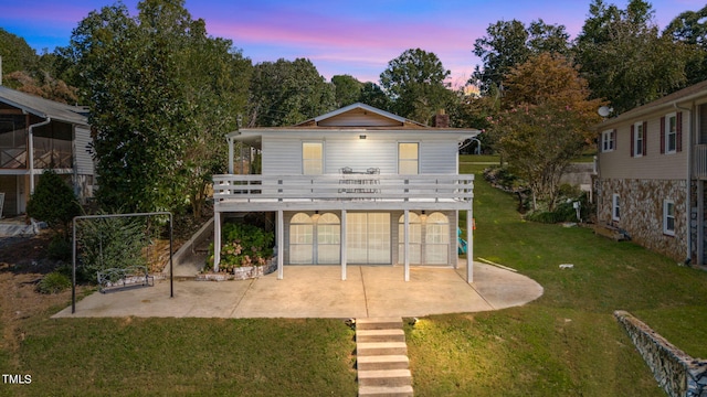 exterior space featuring a wooden deck, a lawn, and a patio area