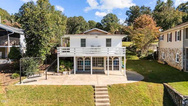 back of property with a patio, a lawn, and a deck