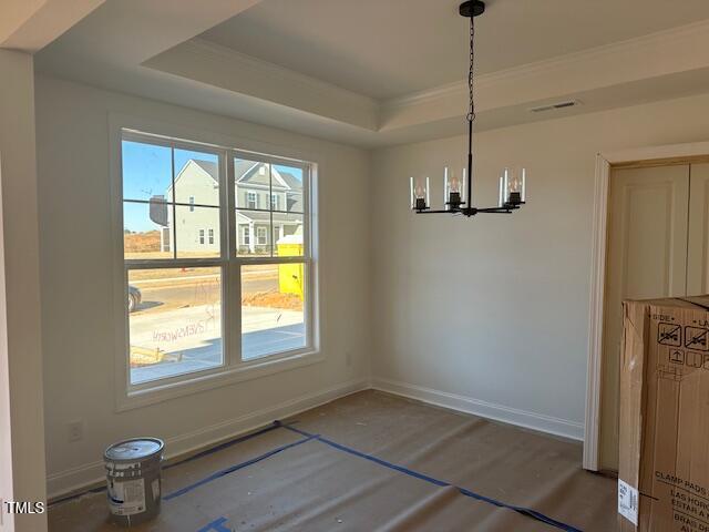 unfurnished dining area featuring hardwood / wood-style flooring, an inviting chandelier, and a raised ceiling