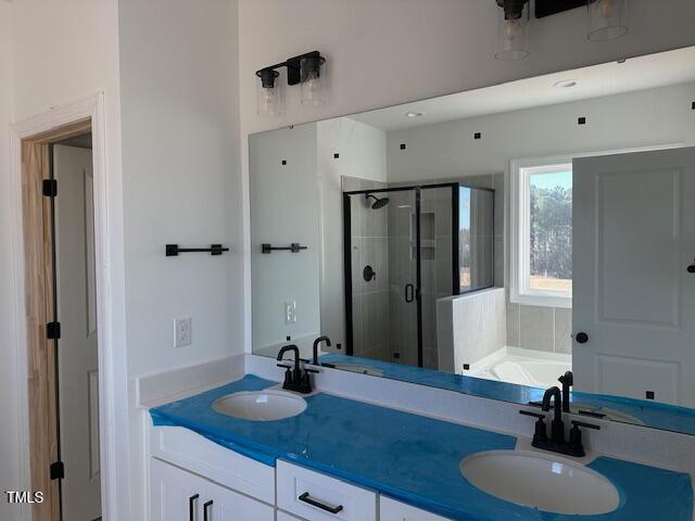 bathroom featuring shower with separate bathtub and vanity