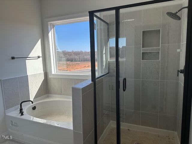 bathroom featuring shower with separate bathtub