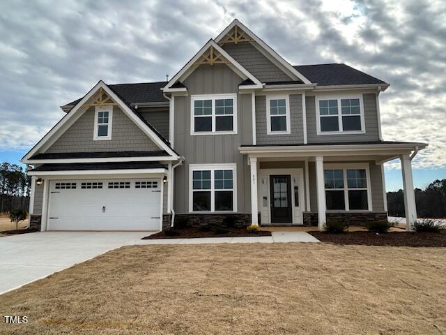 craftsman house featuring a front lawn, a garage, and a porch