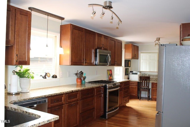 kitchen featuring light stone counters, pendant lighting, appliances with stainless steel finishes, dark hardwood / wood-style flooring, and decorative backsplash