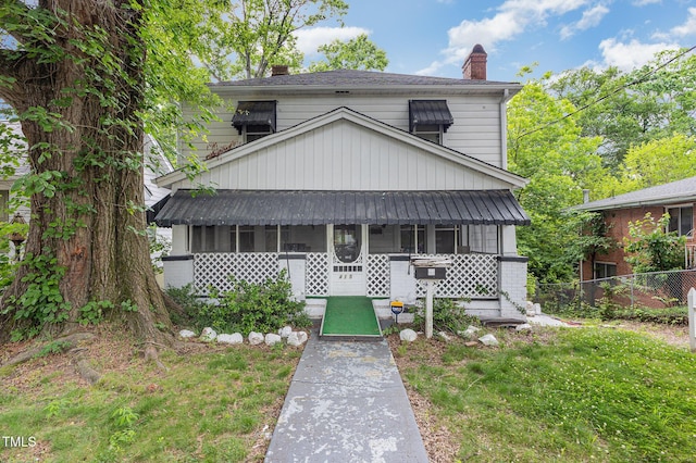 view of front facade with fence, a chimney, and a front lawn