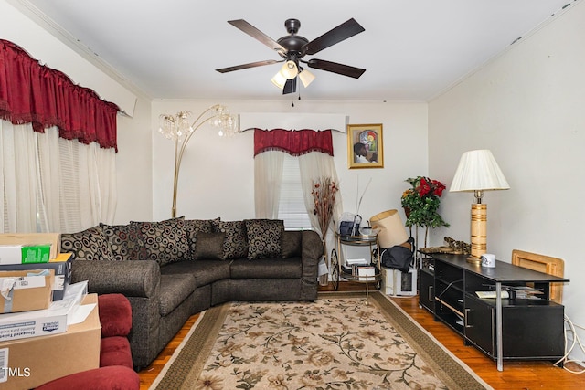 living room featuring ornamental molding, a ceiling fan, and wood finished floors