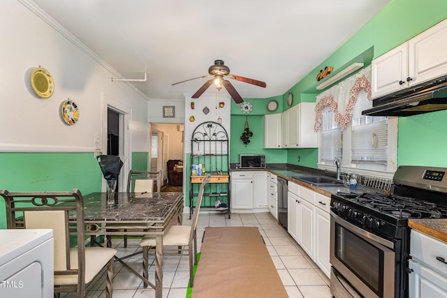 kitchen featuring ceiling fan, appliances with stainless steel finishes, a sink, under cabinet range hood, and light tile patterned flooring