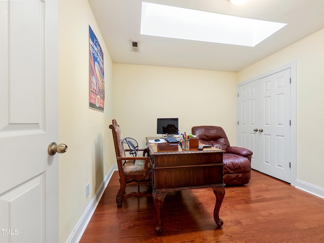 office space featuring hardwood / wood-style flooring and a skylight