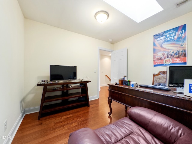 office area featuring hardwood / wood-style floors and a skylight