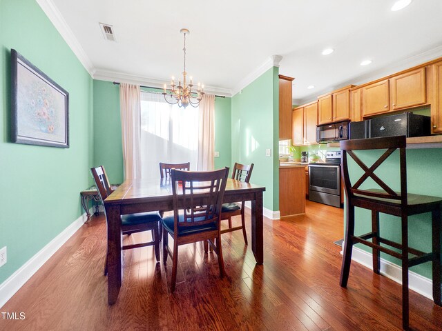 dining room featuring crown molding, dark hardwood / wood-style floors, and a notable chandelier