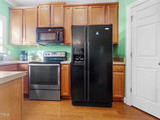 kitchen with black appliances and light hardwood / wood-style flooring