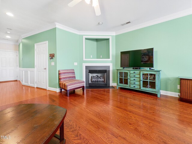 living room featuring ceiling fan, wood-type flooring, and ornamental molding