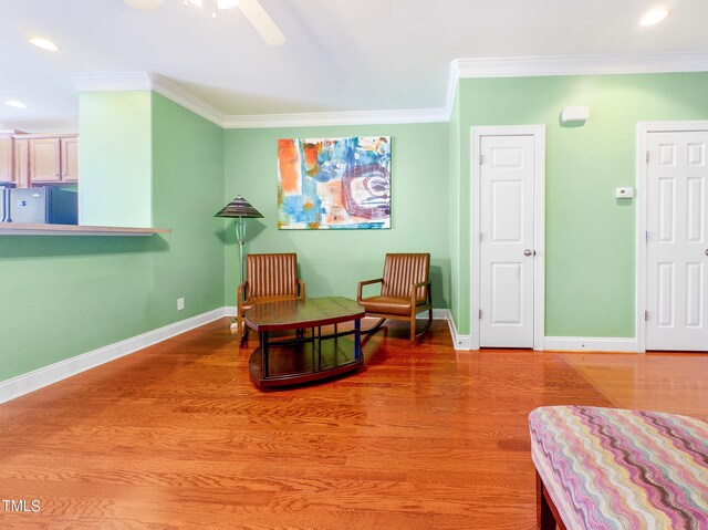 sitting room with ornamental molding, hardwood / wood-style flooring, and ceiling fan