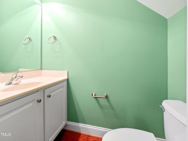 bathroom featuring toilet, lofted ceiling, and vanity