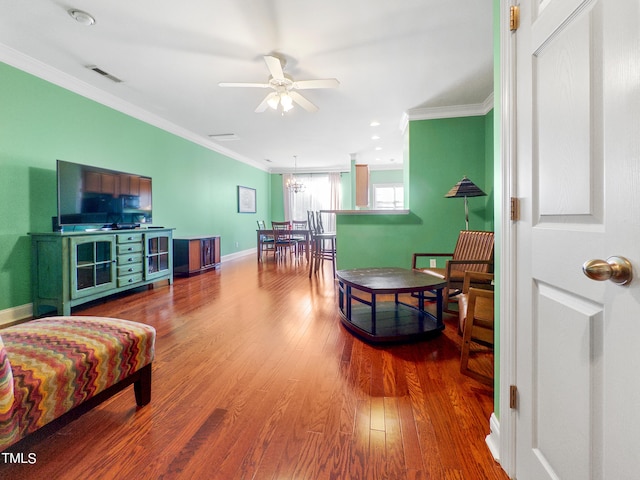 living room with crown molding, wood-type flooring, and ceiling fan