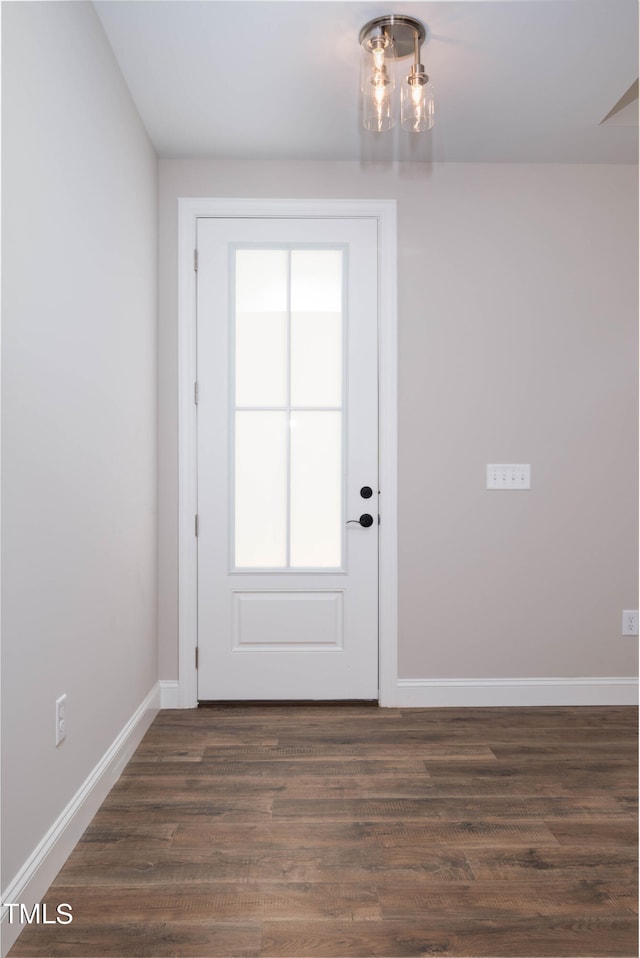 doorway to outside featuring dark hardwood / wood-style floors and an inviting chandelier