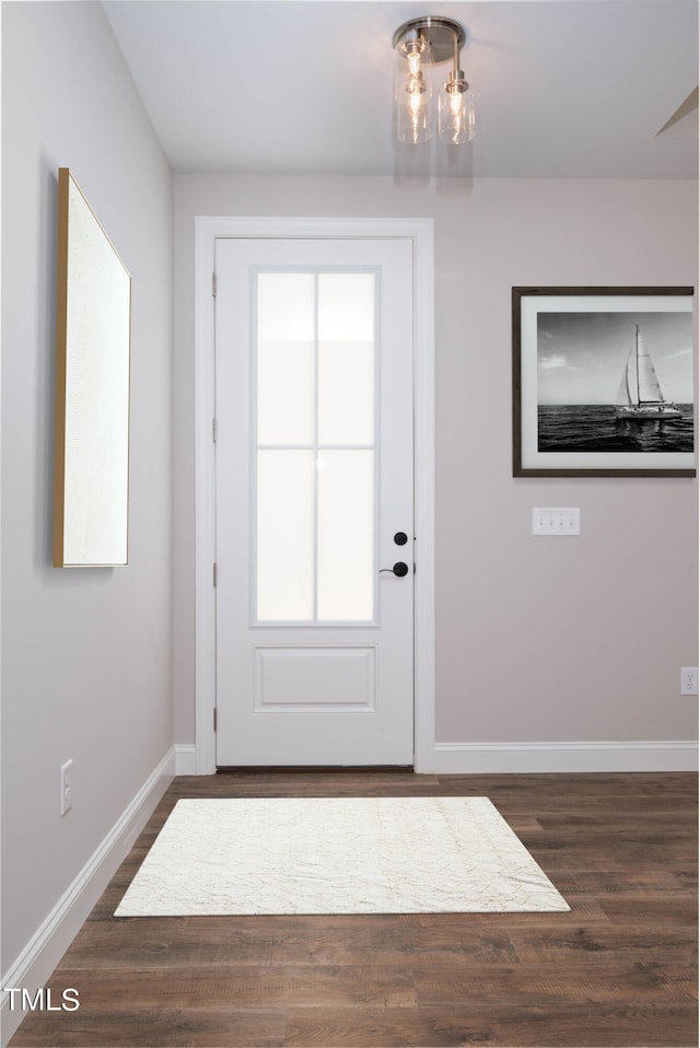 doorway to outside featuring a chandelier and dark hardwood / wood-style flooring