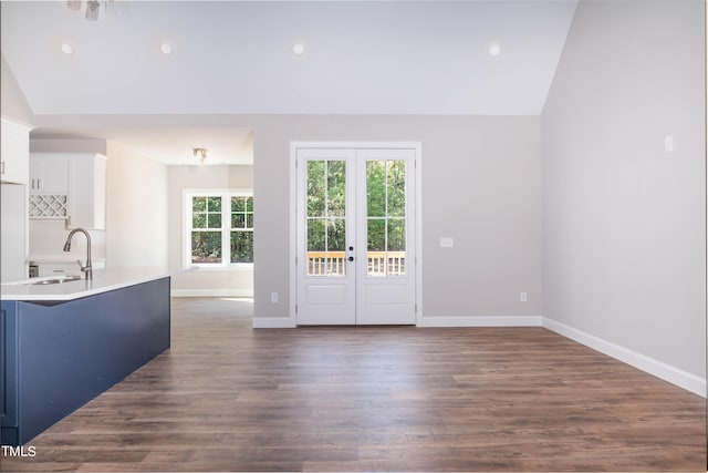 interior space featuring lofted ceiling, sink, white cabinets, and dark wood-type flooring