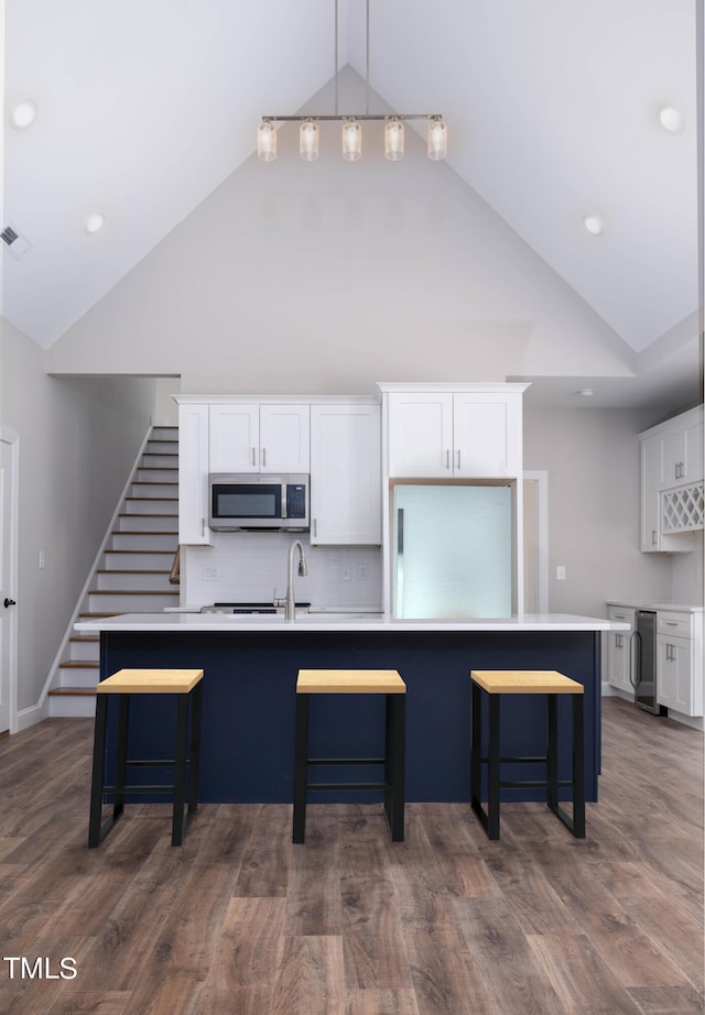 kitchen with white cabinetry, dark wood-type flooring, and a kitchen bar