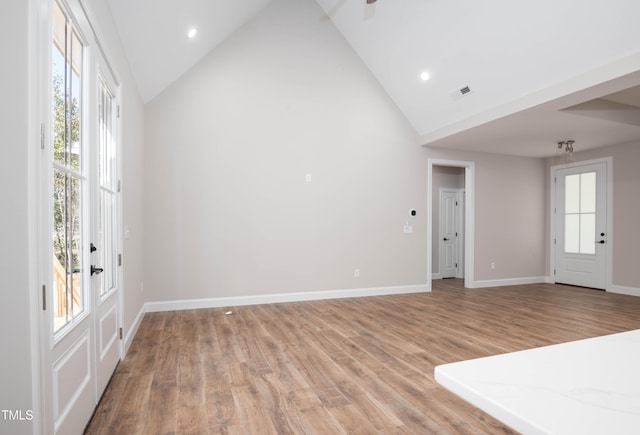 entrance foyer with high vaulted ceiling and light hardwood / wood-style floors