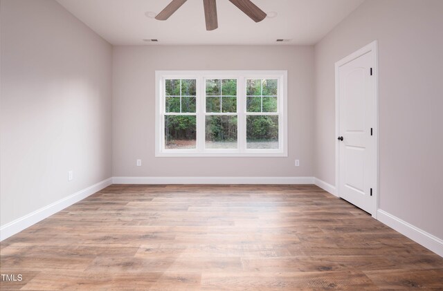 empty room with ceiling fan and wood-type flooring