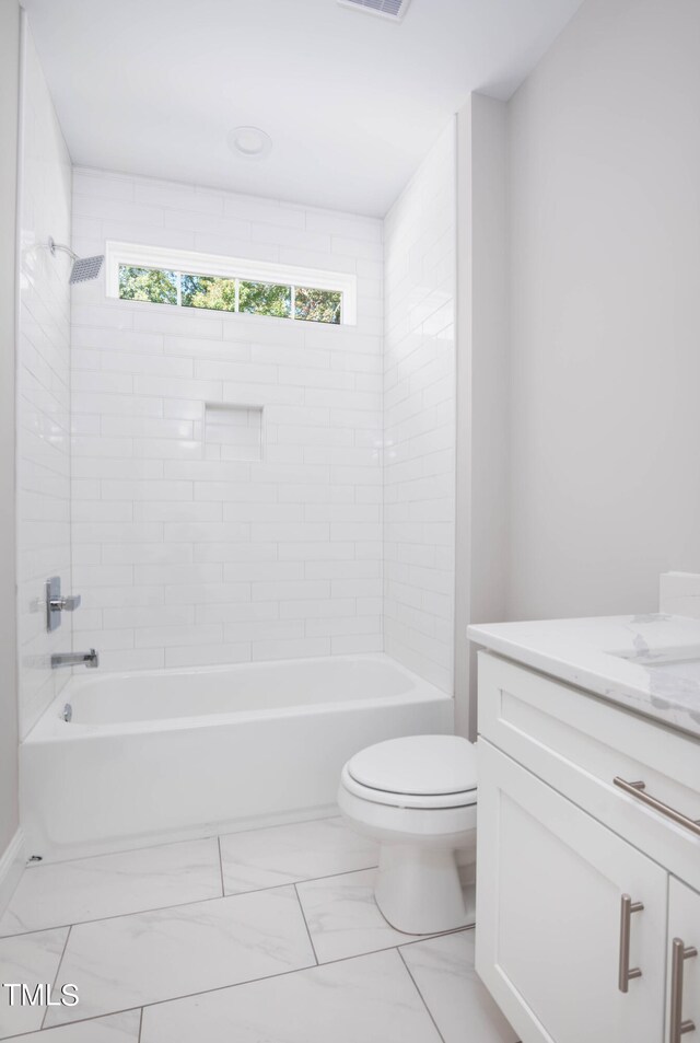 full bathroom featuring tiled shower / bath, vanity, and toilet