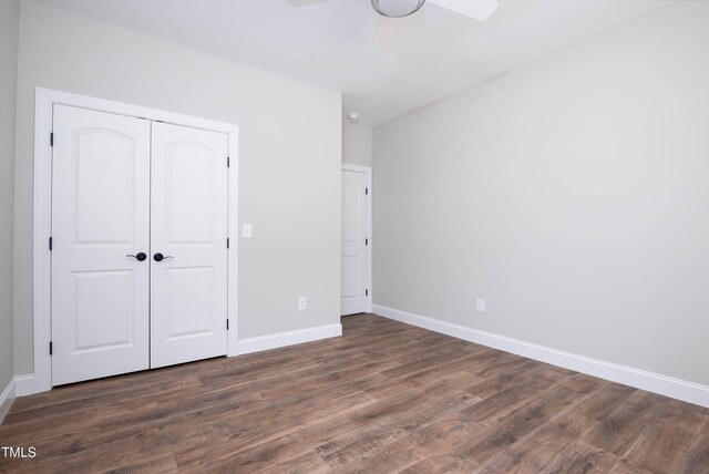 unfurnished bedroom with a closet, dark wood-type flooring, and ceiling fan