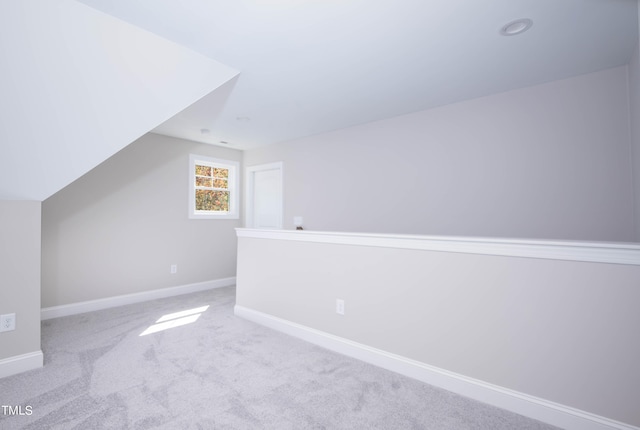 bonus room featuring lofted ceiling and light carpet