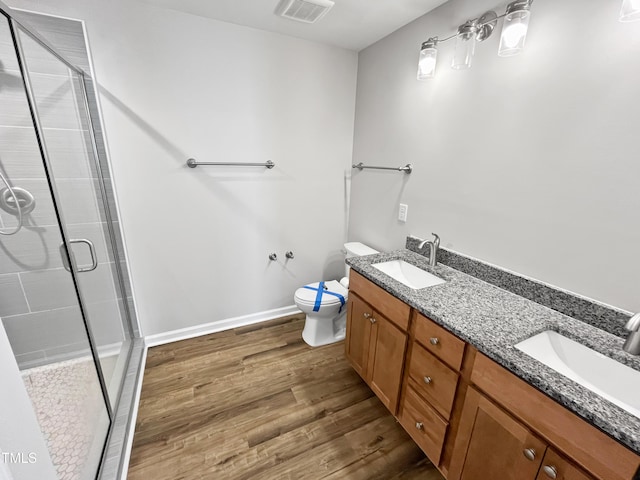 1505 Juniper St, Durham, NC 27703 - full bathroom with a stall shower, wood finished floors, toilet, and double vanity