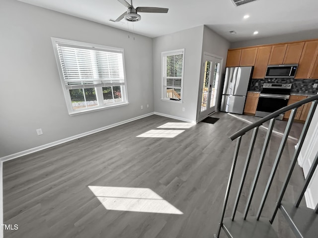 1505 Juniper St, Durham, NC 27703 - kitchen featuring appliances with stainless steel finishes, baseboards, ceiling fan, dark wood-style floors, and backsplash