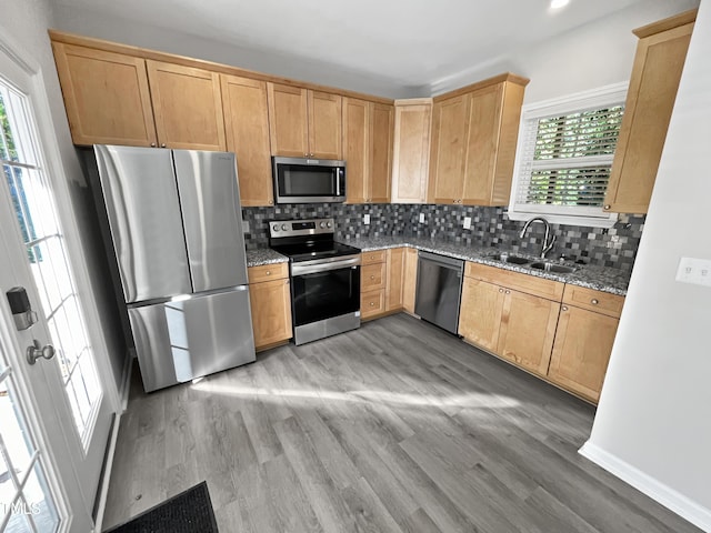 1505 Juniper St, Durham, NC 27703 - kitchen featuring stainless steel appliances, a sink, light stone counters, tasteful backsplash, and light wood finished floors