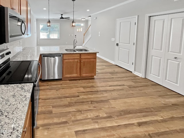 1505 Juniper St, Durham, NC 27703 - kitchen with appliances with stainless steel finishes, a sink, a peninsula, ornamental molding, and ceiling fan
