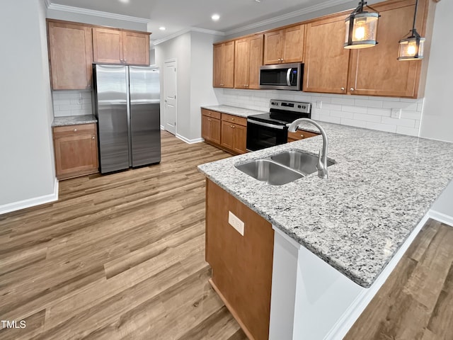 1505 Juniper St, Durham, NC 27703 - kitchen with appliances with stainless steel finishes, a sink, a peninsula, baseboards, and ornamental molding