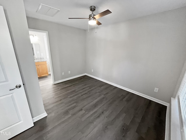 1505 Juniper St, Durham, NC 27703 - unfurnished bedroom featuring dark wood finished floors, baseboards, ensuite bath, and a ceiling fan