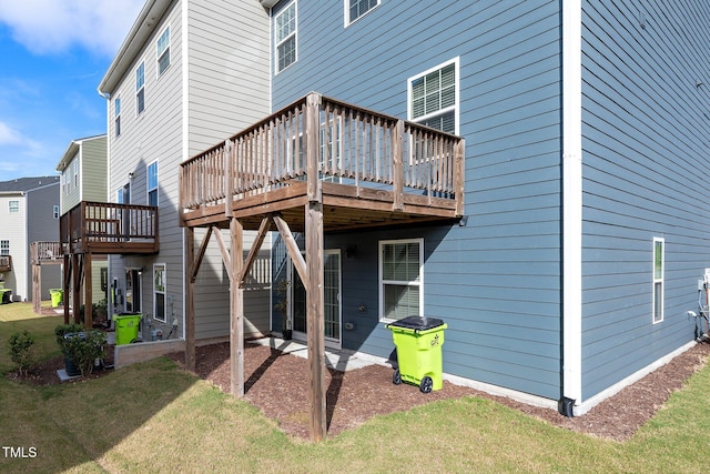 rear view of house with a yard and a wooden deck