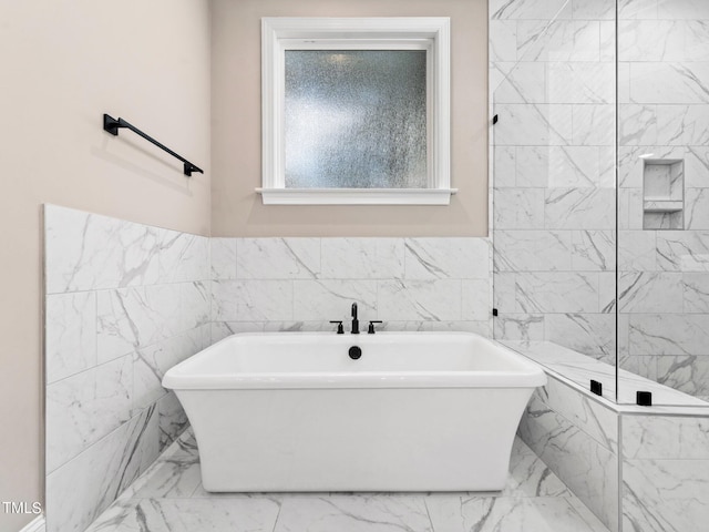 bathroom featuring tile walls and independent shower and bath