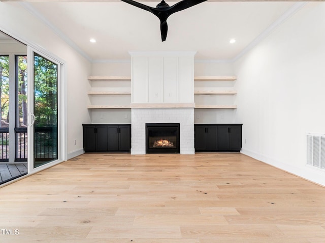 unfurnished living room featuring crown molding, a fireplace, ceiling fan, and light wood-type flooring