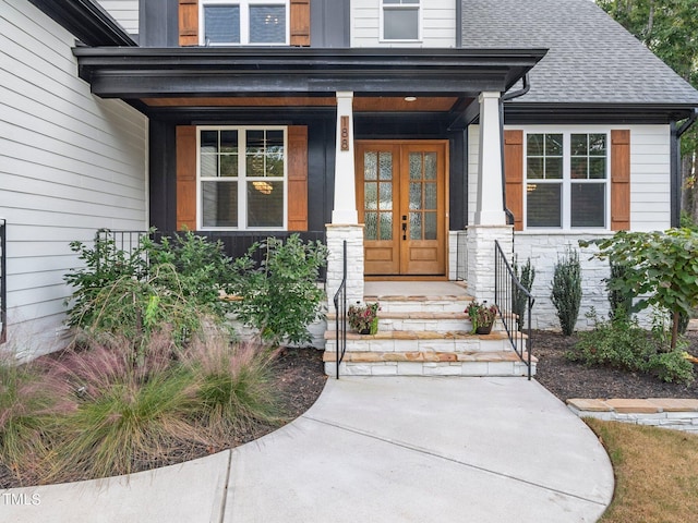 property entrance featuring french doors and a shingled roof