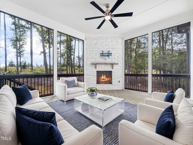 sunroom / solarium with a fireplace and ceiling fan