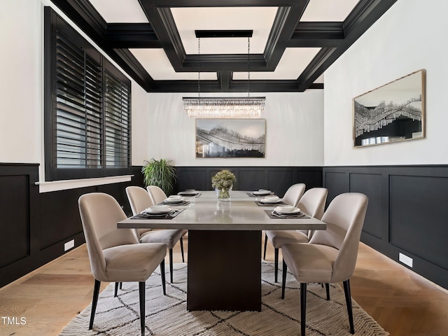 dining area with beamed ceiling, ornamental molding, a notable chandelier, and coffered ceiling