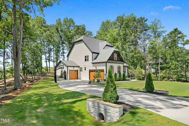 view of front of home with a garage, driveway, a front lawn, and roof with shingles