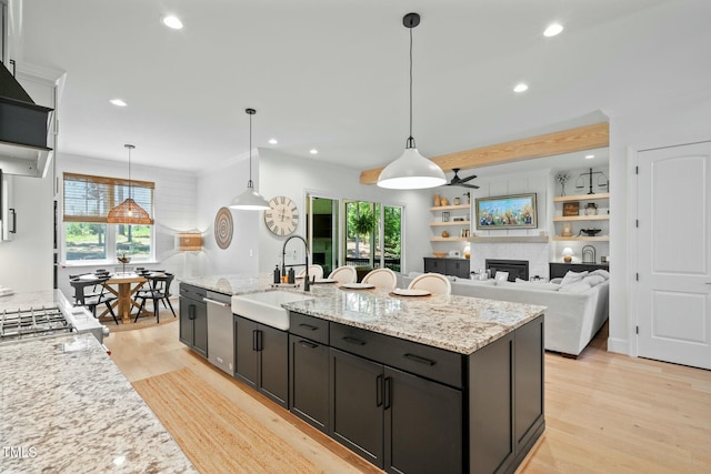 kitchen featuring light wood finished floors, a sink, and recessed lighting