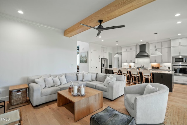 living room with recessed lighting, a ceiling fan, light wood-style floors, beamed ceiling, and crown molding