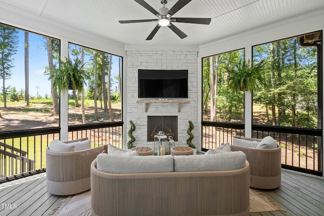 sunroom / solarium featuring a fireplace and a ceiling fan