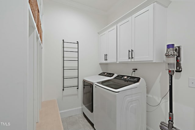 washroom with ornamental molding, cabinet space, independent washer and dryer, and baseboards