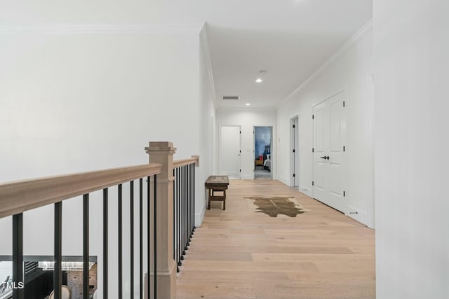 corridor with baseboards, visible vents, light wood-style flooring, crown molding, and recessed lighting