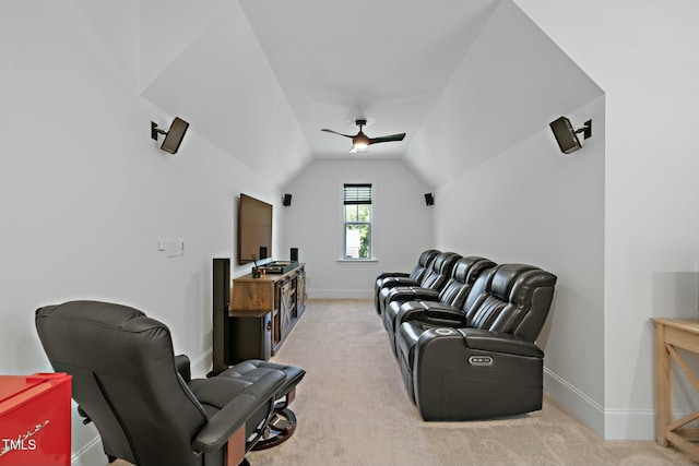 carpeted home theater room with vaulted ceiling, a ceiling fan, and baseboards