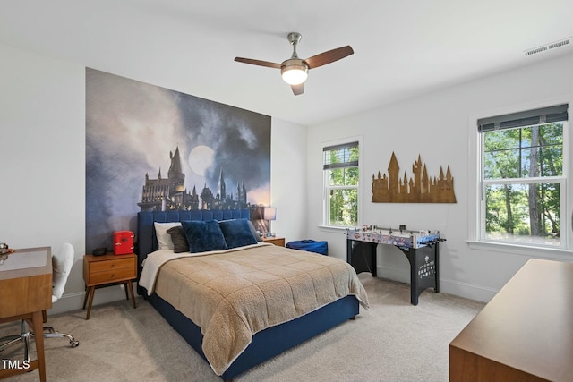 bedroom featuring baseboards, ceiling fan, visible vents, and light colored carpet