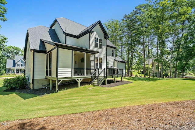 rear view of house with a yard and roof with shingles