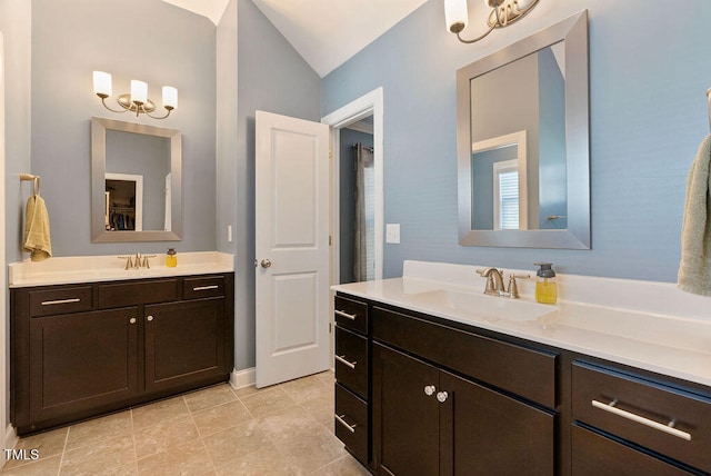 bathroom with lofted ceiling, tile patterned floors, vanity, and an inviting chandelier